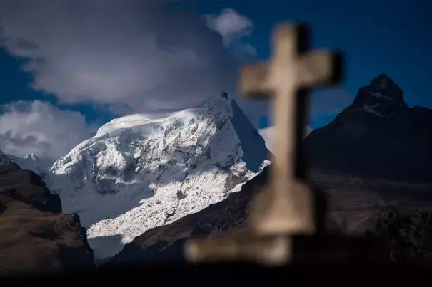 An Andes mountain range and a cross headstone are seen from Cementerio Municipal De Huaraz in Huaraz, in the Ancash region of Peru, on July 13. Photo: Jabin Botsford