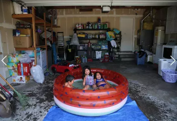 Sisters Nyla Herrera, 9, right, and Jaylah, 5, and their cousin Damon Knight, 6, swim in a kiddie pool in the girl's family garage to stay out of the heat of the direct sunlight in Santa Rosa on Monday, June 10, 2019. Photo: Beth Schlanker, The Press Democrat