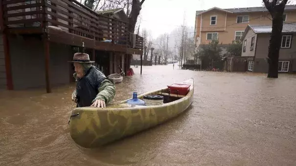 Sycamore Court resident Jesse Hagan evacuates to higher ground from an apartment complex in lower Guerneville, Calif., on Tuesday. Photo: Kent Porter, The Press Democrat
