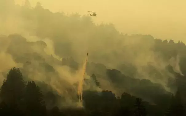 A firefighter stands on steep terrain while fire crews create fire breaks at Garrapata State Park during the Soberanes Fire north of Big Sur, California, U.S. July 31, 2016. Photo: Michael Fiala, Reuters