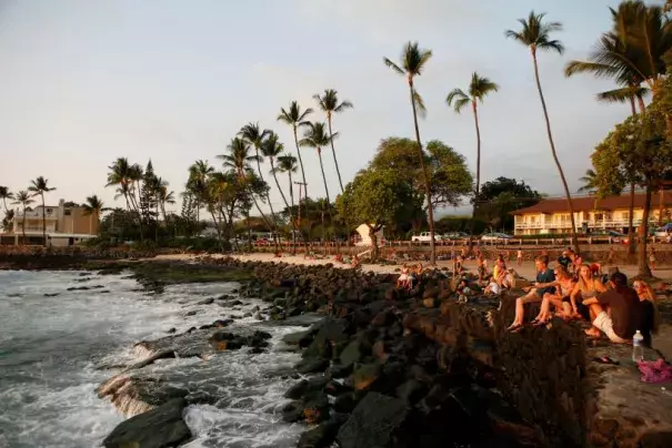 Tourists and locals watch the sunset from White Sands Beach Park in Kailua-Kona, on Hawaii's Big Island, January 31, 2016. Photo: Canice Leung, Reuters
