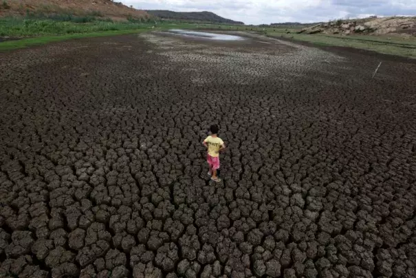 Natan Cabral, 5, stands on the cracked ground of the Boqueirao reservoir in the Metropolitan Region of Campina Grande, Paraiba state, Brazil, February 13, 2017. Photo: Ueslei Marcelino, Reuters