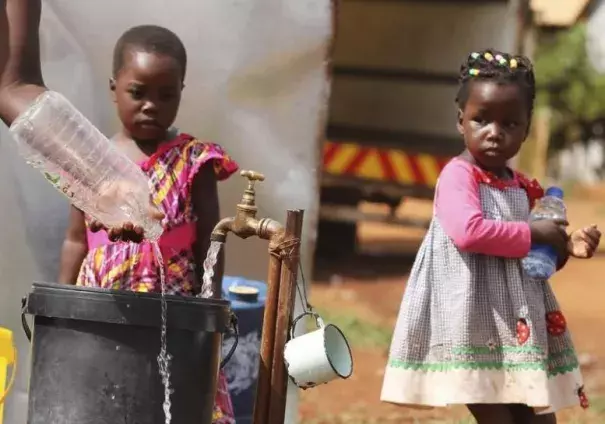 Zimbabwean children watch as their mother collects water from a communal tap in Harare, February 5, 2016. Photo: Reuters, Philimon Bulawayo