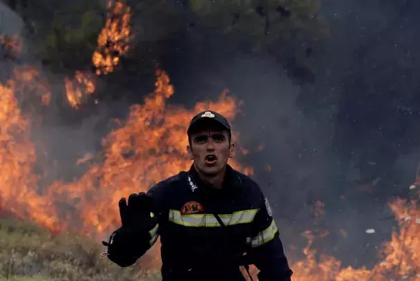 A firefighter reacts as flames rise during a wildfire near the village of Kapandriti, north of Athens, Greece, August 15, 2017. Photo: Alkis Konstantinidis