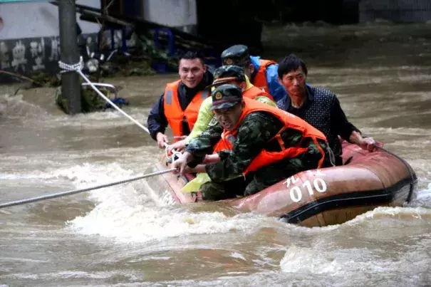 Rescuers grab a rope to prevent a raft carrying residents from being flushed away as residents are evacuated from a flooded area in Jiujiang, Jiangxi Province, China, June 19, 2016. Photo: Reuters / Stringer