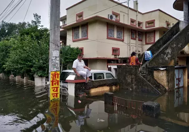 A man sits on a boundary wall of a house as he waits to be evacuated from a flood-affected neighbourhood in Patna, in the eastern state of Bihar, India, October 1, 2019. Photo: Reuters/Stringer