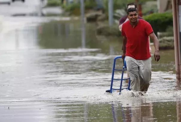 A pedestrian walks through a flooded street with a hand truck to get sand bags to deliver to local businesses during a flash flood as a result of heavy rains from tropical storm Rosa Tuesday, Oct. 2, 2018, in Phoenix. Photo: Ross D. Franklin, AP