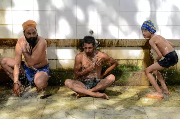 Two Indian men and a boy cool off in Amritsar, India, on Tuesday. Photo: Narinder Nanu, AFP/Getty Images