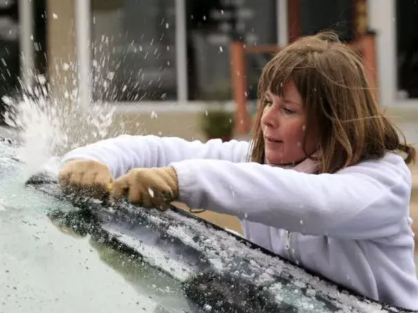 Krystal Wright scrapes ice from her car's windshield Friday, Nov. 27, 2015 in Wichita, Kan. The winter weather left a layer of ice on roads and cars early Friday morning after a heavy rain on Thanksgiving day that set a record with over 2 inches of rain. Photo: Brian Corn, The Wichita Eagle via AP