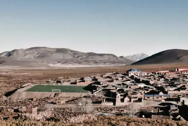 The population of Santiago K, which had been thriving with growing demand for quinoa, fell sharply as a drought lingered into a second year in Bolivia. The artificial surface of its soccer field stands out against the dry ground. Photo: Ben Walker