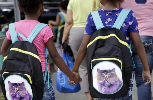 In this file photo, children in Miami hold hands as they walk with their new book bags. Photo: Lynne Sladky, AP