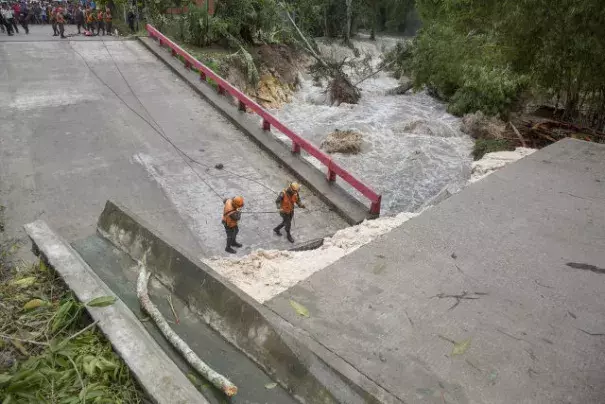 A handout picture made available by the National Coordination for Disaster Reduction of Guatemala (CONRED) shows members of the national army emergency and rescue team (UHR) working at a fallen bridge damaged after strong rains hit the region, following the passage of Tropical Storm Earl, in Melchor de Mencos, Guatemala, August 4, 2016. Photo: CONRED / EPA