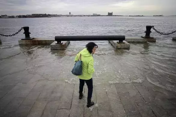 Lynda DeBiccari waded in as the water rose during a King tide at the end of Long Wharf. Photo: Lane Turner