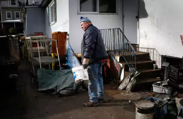 A man takes a break from cleaning out his home flooded by Superstorm Sandy in the Hudson River town of Piermont, New York, November 8, 2012. Photo: Mike Segar, Reuters