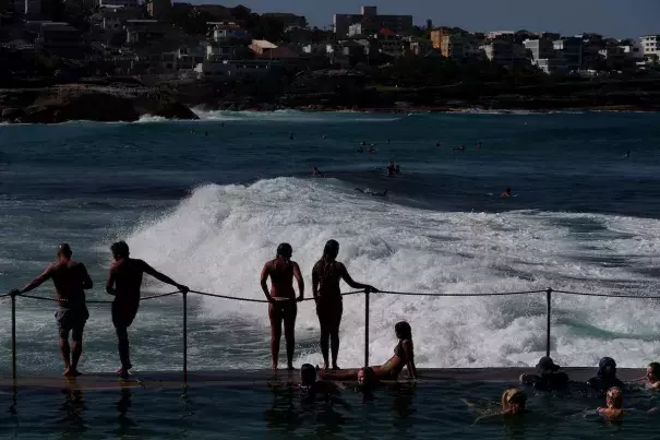 People are shown standing next to ocean waves.