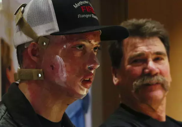 Daniel Lyon, Jr., the firefighter who survived the deadly Twisp blaze, speaks during a news conference at Harborview Medical Center on Wednesday in Seattle. At right is his father, Daniel Sr. (Ken Lambert / The Seattle Times)