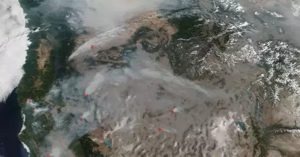 A satellite image of smoke from wildfires in the Pacific Northwest in August 2018, with active fires labeled in red. Image: NASA