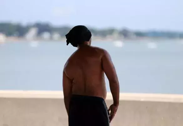 A man took to the shade at Wollaston Beach in Quincy on what promised to be a hot summer day Thursday morning. Photo: Jonathan Wiggs, Globe Staff