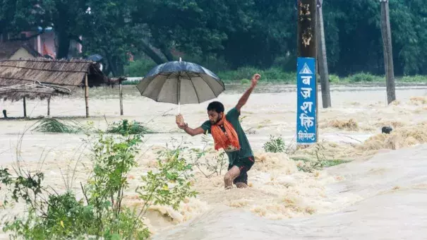 A Nepalese man looses his balance while crossing a flooded street in Birgunj, Nepal, Sunday, Aug. 13, 2017. An official said torrential rain, landslides and flooding have killed dozens of people in Nepal over the past three days, washing away hundreds of homes and damaging roads and bridges across the Himalayan country. Photo: Manish Paudel, AP