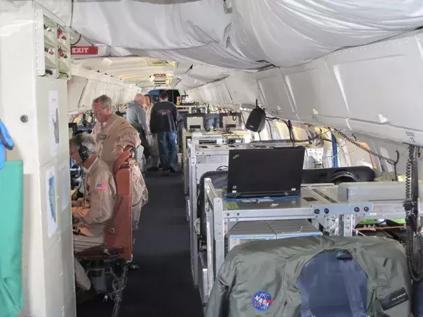 Researchers record data on the NASA DC-8 during a flight of the NASA IceBridge program. Photograph courtesy Ted Scambos.