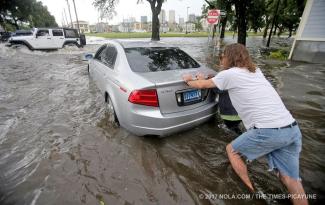 Good Samaritans push a flooded car with a family from the waters in the 2000 block of Orleans Avenue as an afternoon deluge flooded the streets of New Orleans on Saturday, July 22, 2017. Photo: Michael DeMocker, NOLA.com, The Times-Picayune