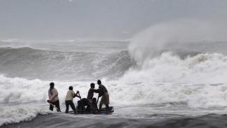 Indian fishermen negotiate their skiff through rough waves ahead of Cyclone Hudhud. Photo: STRDEL/AFP/Getty
