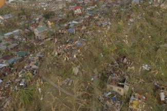In this photo provided by the Philippine Navy, damaged houses and toppled trees lie in Dinagat Island, Surigao del Norte province, southern Philippines on Friday, Dec. 17, 2021. The governor of an island province in the central Philippines said dozens of people died in the devastation wrought by Typhoon Rai in just half of the towns that managed to contact him, bringing the death toll in the strongest typhoon to batter the country this year to nearly 100. (Philippine Navy via AP)