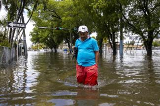 A man crosses the flooded intersection near Southwest Fourth Street and Eighth Avenue in the Little Havana neighborhood of Miami, Saturday, June 4, 2022. (Credit: Daniel A. Varela/Miami Herald via AP)