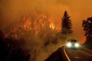 A firetruck drives along California Highway 96 as the McKinney Fire burns in Klamath National Forest, Calif., Saturday, July 30, 2022. (Credit: AP Photo/Noah Berger)