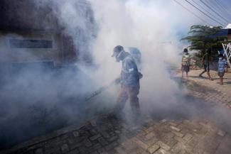 FILE - A worker fumigates a neighborhood with anti-mosquito fog to control dengue fever in Medan, North Sumatra, Indonesia, Feb. 1, 2022. Climate hazards such as flooding, heat waves and drought have worsened more than half of the hundreds of known infectious diseases in people, such as zika, dengue, hantavirus, cholera and even anthrax, according to a new study released Monday, Aug. 8. (Credit: AP Photo/Binsar Bakkara, File)