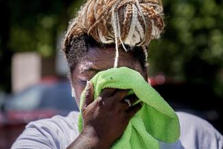FILE - Nicole Brown wipes sweat from her face while setting up her beverage stand near the National Mall on July 22, 2022, in Washington. What's considered officially “dangerous heat” in coming decades will likely hit much of the world at least three times more often as climate change worsens, according to a new study. (Credit: AP Photo/Nathan Howard, File)