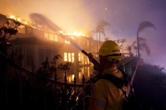 A firefighter works to put at a structure burning during a wildfire Wednesday, May 11, 2022, in Laguna Niguel, Calif. (Credit: AP Photo/Marcio J. Sanchez)