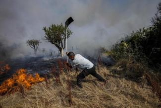 A local resident fights a forest fire with a shovel during a wildfire in Tabara, north-west Spain, Tuesday, July 19, 2022. Firefighters battled wildfires raging out of control in Spain and France as Europe wilted under an unusually extreme heat wave that authorities in Madrid blamed for hundreds of deaths. (Credit: AP Photo/Bernat Armangue)