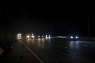 Drivers drive on a dark road after the passing of Hurricane Fiona that left the parts of the island without power, in San Juan, Puerto Rico, Tuesday, Sept. 20, 2022. (AP Photo/Stephanie Rojas)
