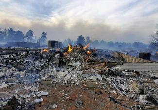 This Wednesday April 20, 2022, photo provided by Bill Wells shows his home on the outskirts of Flagstaff, Ariz., destroyed by a wildfire on Tuesday, April 19, 2022. The wind-whipped wildfire has forced the evacuation of hundreds of homes and animals. (Credit: Bill Wells via AP)