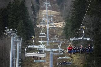 People ride the cable car above the ski track without any snow on Bjelasnica mountain near Sarajevo, Bosnia, Wednesday, Jan. 4, 2023. (Credit: AP Photo/Armin Durgut)
