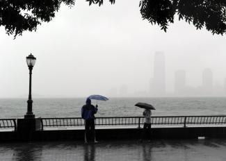 A couple looks at the view of New Jersey from Battery Park in Lower Manhattan on Aug. 28, 2011, as Hurricane Irene hit the region with rain and high winds. Coastal flooding from this week's blizzard may match or exceed Irene's levels. Photo: Stan Honda, AFP/Getty Images