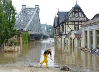 A helper cleans the bank of river Elbe in front of the historical bridge Blaues Wunder (Blue Miracle), left, in Dresden, eastern Germany, Thursday, June 6, 2013. Photo: Jens Meyer, AP