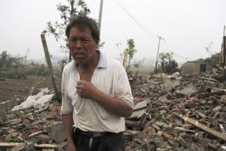 A villager stands near houses destroyed in the aftermath of a tornado that hit Funing county in Yancheng city in eastern China's Jiangsu Province on Thursday, June 23, 2016. Photo: Color China Photo via AP