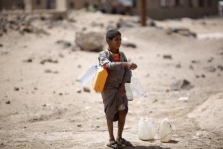 A boy carries buckets filled with water from a public tap amid an acute shortage of water, on the outskirts of Sanaa, Yemen. Water scarcity has been blamed for contributing to instability in the country. Photo: Hani Mohammed, Associated Press