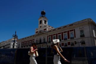 A woman covers her head with a bag as she walks at Puerta del Sol square during a hot day as Spain braces for a heatwave in Madrid, Spain, June 10, 2022. (Credit: REUTERS/Susana Vera/File Photo)