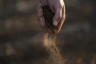 FILE - Farmer Barry Evans drops dusty soil from a cotton crop he shredded and planted over with wheat, Oct. 3, 2022, in Kress, Texas. A new study finds that climate change is making droughts faster and more furious — and especially one fast-moving kind of drought that can take farmers by surprise. (Credit: AP Photo/Eric Gay, File)
