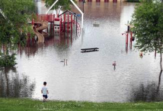 The rising Mississippi River covered a playground and closed roads on Tuesday in St. Paul. Photo: Jim Mone, Associated Press