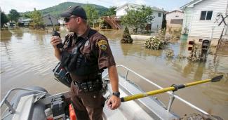 Lt. Dennis Feazell, of the West Virginia Department of Natural Resources, contacts his command center as he and a co-worker search flooded homes in Rainelle, W. Va., Saturday, June 25, 2016. Photo: AP