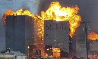 A grain elevator burns in Denton, Montana, on 1 December. Unusually warm temperatures have helped spur late wildfires, with flames roaring across the prairies of Montana. (Photograph Credit: AP)