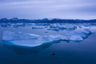 FILE - A boat navigates at night next to large icebergs near the town of Kulusuk, in eastern Greenland on Aug. 15, 2019. A sharp spike in Greenland temperatures since 1995 showed the giant northern island 2.7 degrees (1.5 degrees Celsius) hotter than its 20th-century average, the warmest in more than 1,000 years, according to new ice core data. (Credit: AP Photo/Felipe Dana, File)