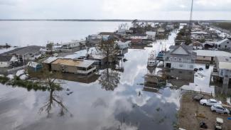 FILE - In this aerial photo taken with a drone, flood waters surround storm damaged homes on Aug. 31, 2021, in Lafourche Parish, La., as residents try to recover from the effects of Hurricane Ida. (AP Photo/Steve Helber, File)