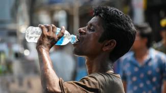 A man is seen drinking water to relieve himself of heat, at a street side in Kolkata, India, on 29 April 2022. (Credit: Debarchan Chatterjee | Nurphoto | Getty Images)