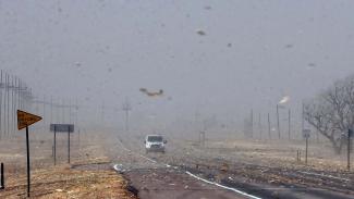 Debris from nearby farm fields swirls around on Highway 400 between Mullinville, Kansas, and Dodge City. (Credit: Travis Heying/The Wichita Eagle (AP))