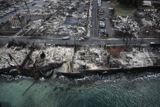 An aerial image shows destroyed homes and buildings burned to the ground in Lahaina along the Pacific Ocean in the aftermath of wildfires in western Maui, Hawaii, on Aug. 10. (Credit: Patrick T. Fallon/AFP/Getty Images)